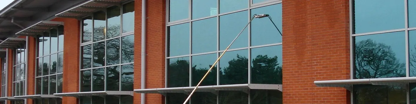 Water-fed pole cleaning the glazing of a commercial building